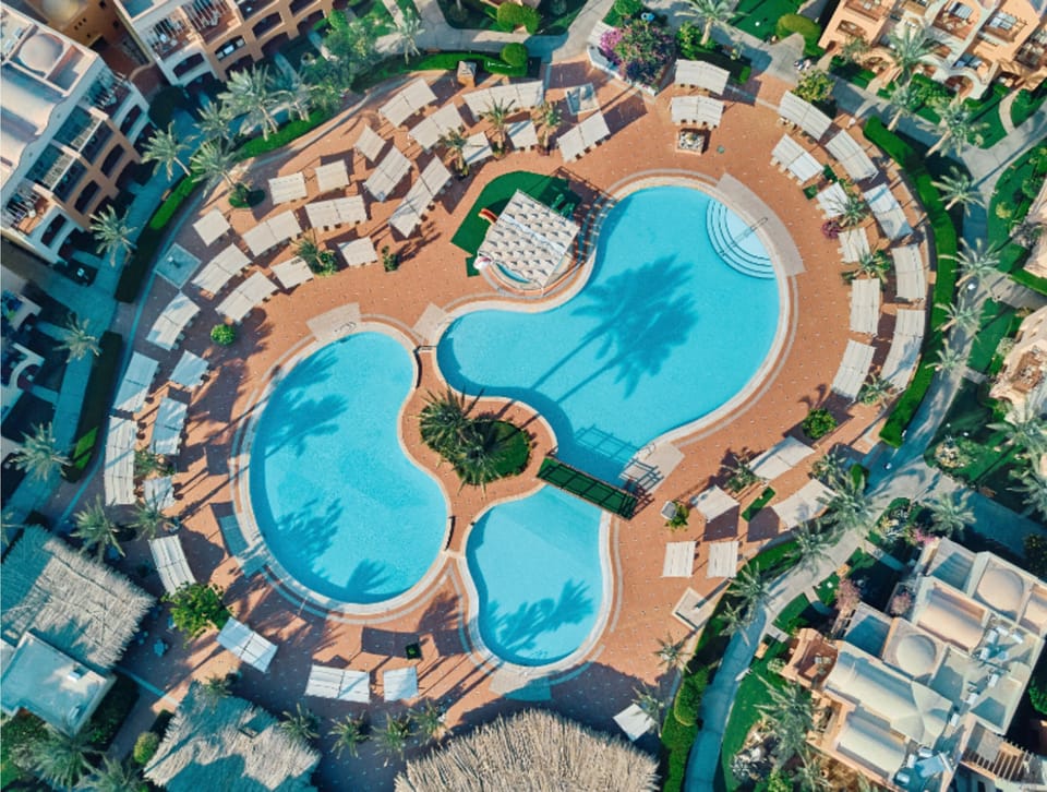 Relax overhead as the pool curves around calm loungers.