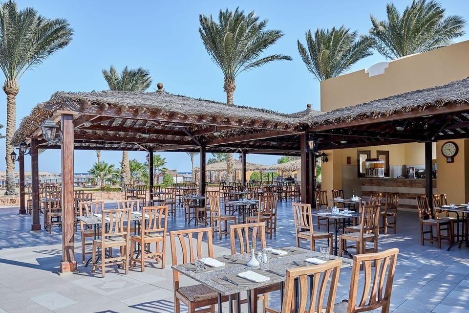 Savor sunny open-air meals beneath breezy palm-shaded pergolas.