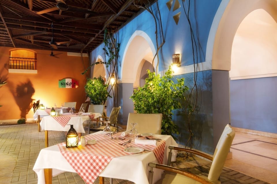 Linger over intimate courtyard dining framed by glowing arches.