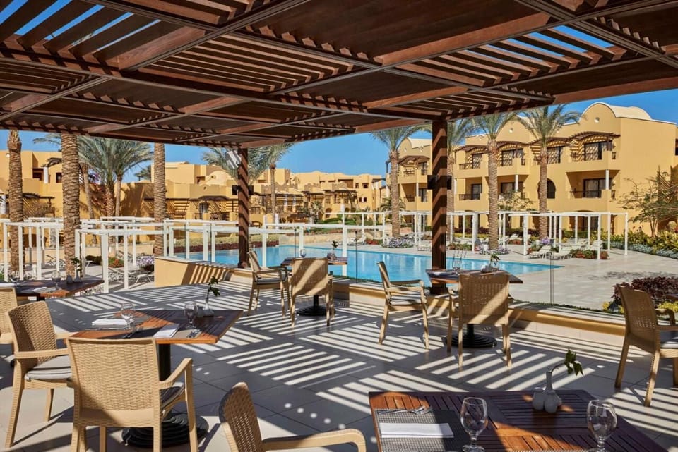Dine alfresco with shaded comfort beside the shimmering pool.