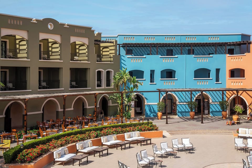 Arrive to a sunlit courtyard wrapped in resort-style architecture.