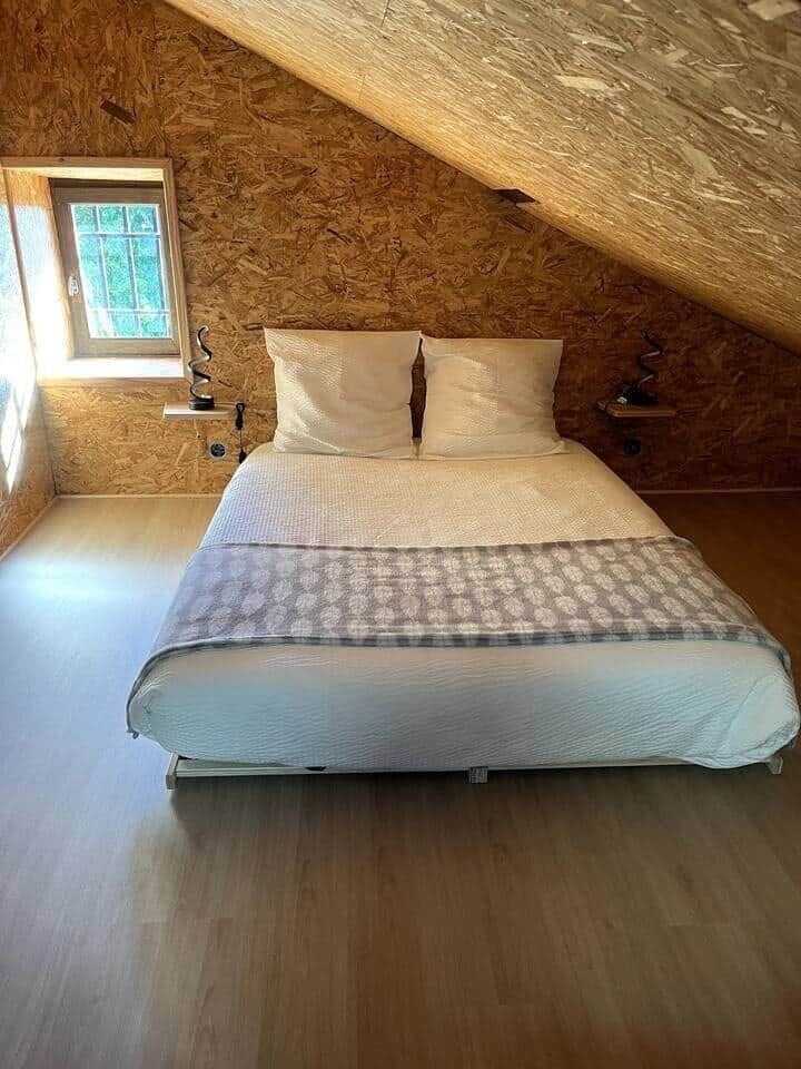 Découvrez notre 4e chambre : grenier avec accès échelle meunier. Lumineuse (2 fenêtres, 1 Velux), elle offre un lit double (140), un espace jeux enfants, et un dortoir modulable avec lits en 90.