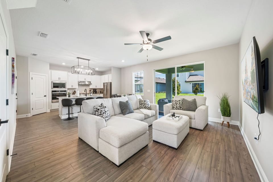 Living room is completed with plush sofa and loveseat, perfect for a family movie night. 