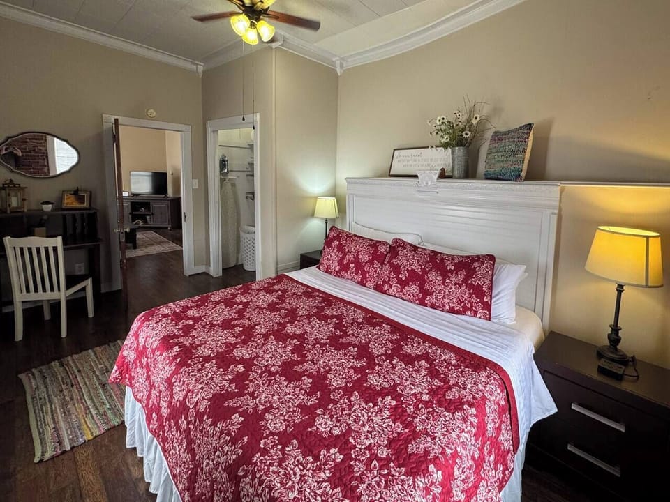 Another view of the bedroom, highlighting the bedside lamp and decor on the nightstand.