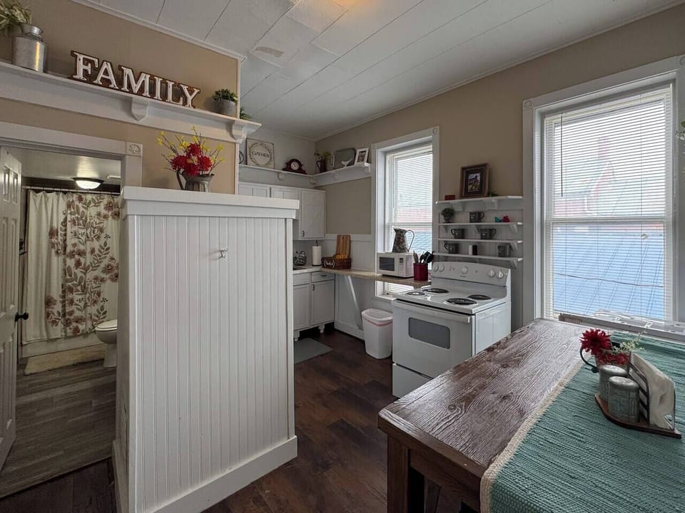 Open concept kitchen and dining area with a rustic wooden table and chairs.