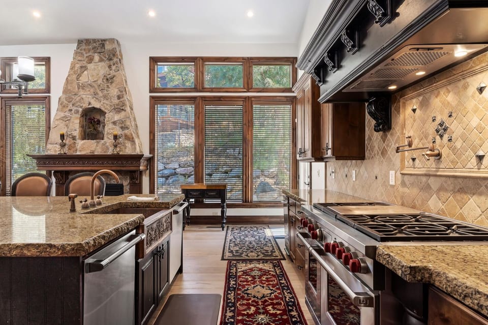 Main Level Kitchen with Large Island & Sink on left and Oven/Stove on right