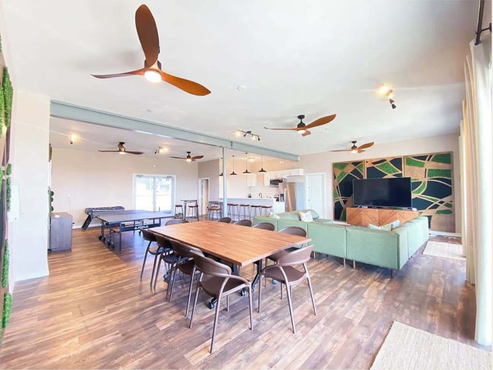 Family area which features living room, dining area, kitchen island with chairs, full kitchen, ping pong table