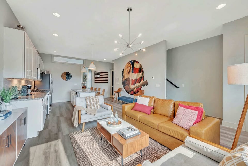 A circular portrait of a guitar player presides over the living room where two sofas and armchairs keep the whole group together, no one left out