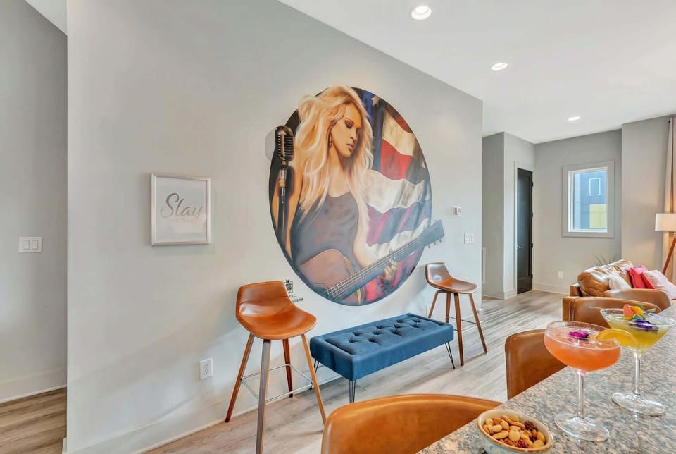 Guitar-player wall art and bar stools in the living room reinforce the Stars & Guitars vibe every time you gather on the main level