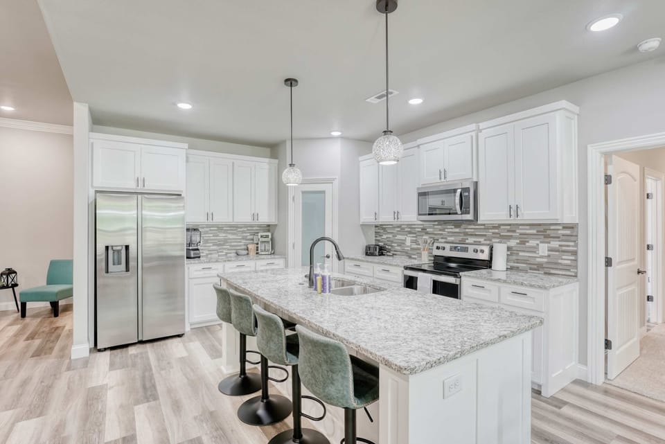 Modern kitchen with stainless steel appliances, granite countertops, and island seating—perfect for cooking and gathering.