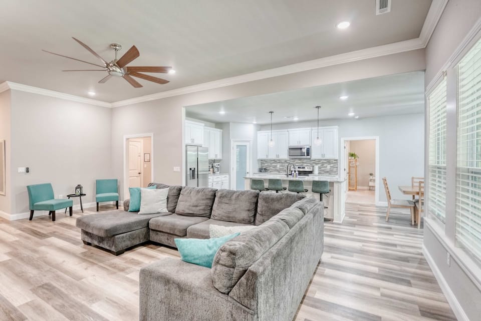 Stylish living area featuring a warm fireplace, spacious sectional seating, and plenty of natural light pouring in through the windows.