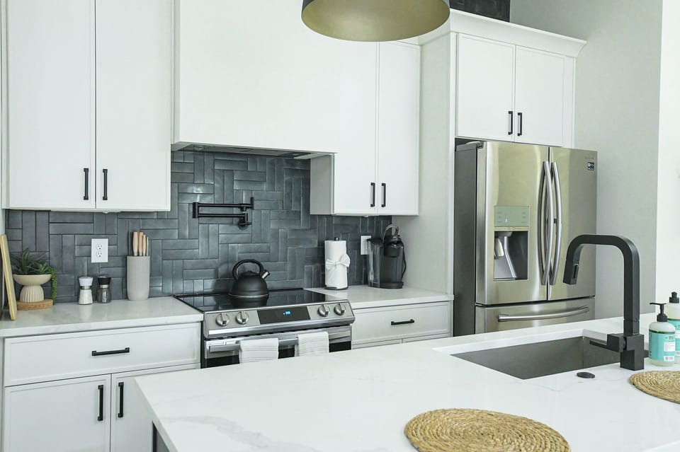 Fully equipped kitchen with stainless steel appliances and open shelving.