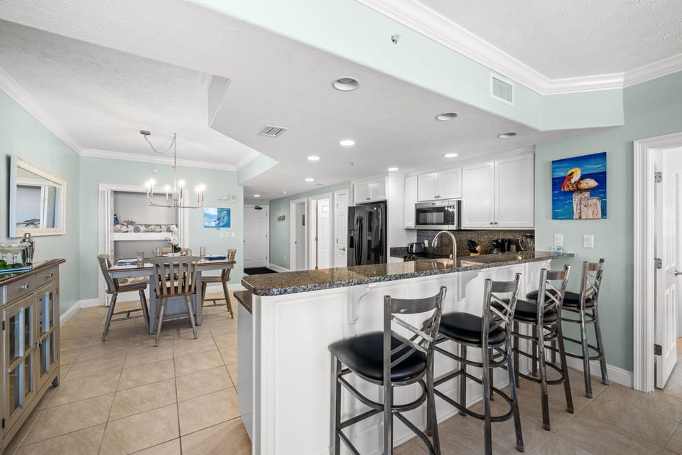 Open kitchen with granite countertops and seating for four in a modern dining area