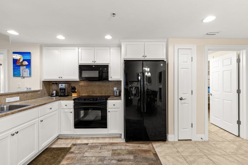 Sleek, fully equipped kitchen w/ modern appliances & gleaming countertops ready for home-cooked meals.