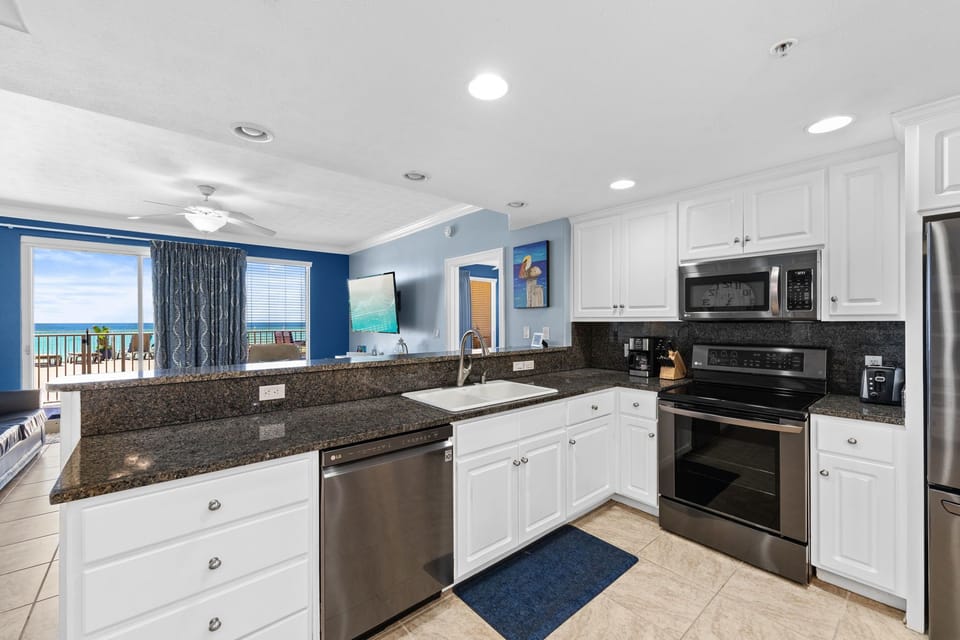 Modern kitchen with granite countertops and ocean views in the background