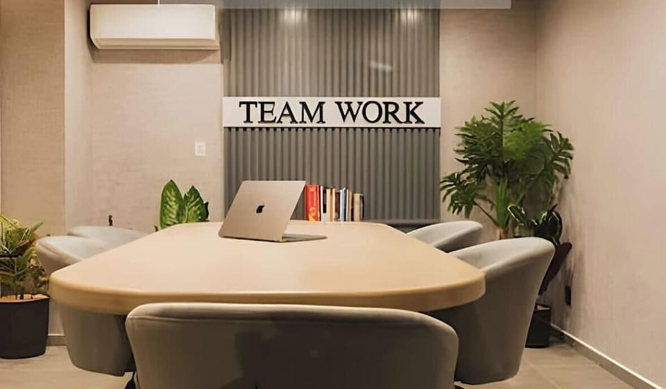 Comfortable lounge meeting space w/ round table, sofa seating & plants