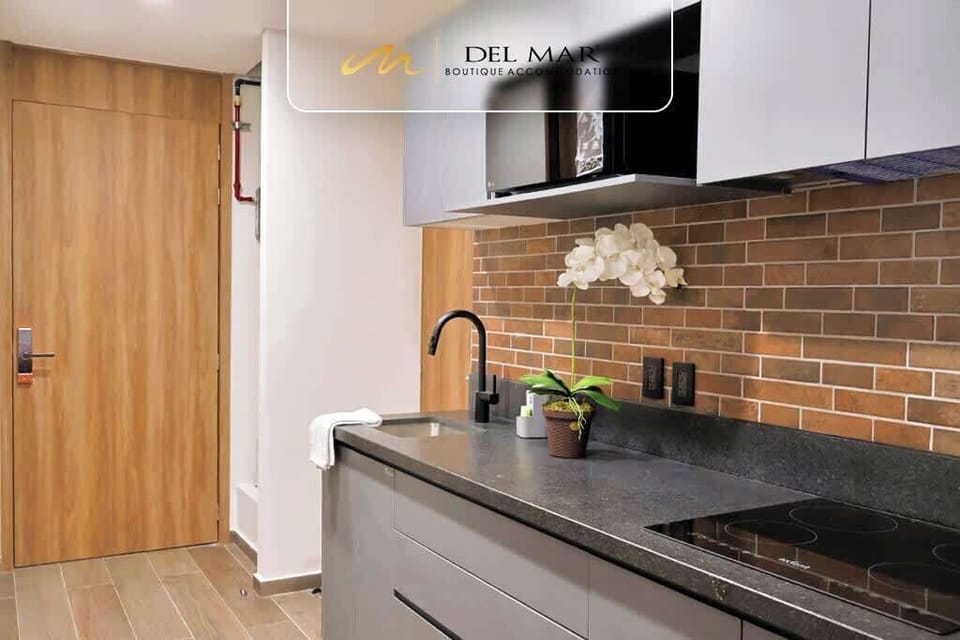 Contemporary kitchen w/ brick backsplash, dark counters & wood cabinetry