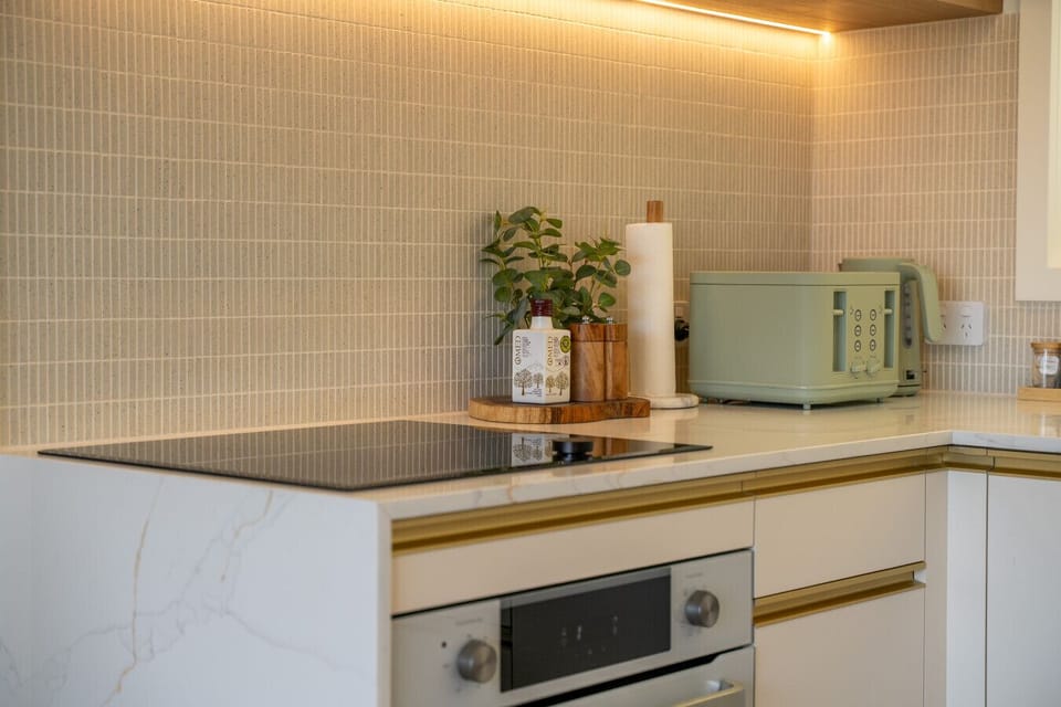 Kitchen with japanese finger tiles & stone bench & induction cooktop