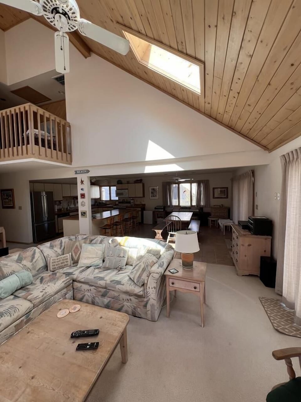 A spacious living area with high ceilings, large windows, and comfortable seating, offering a warm and inviting atmosphere.