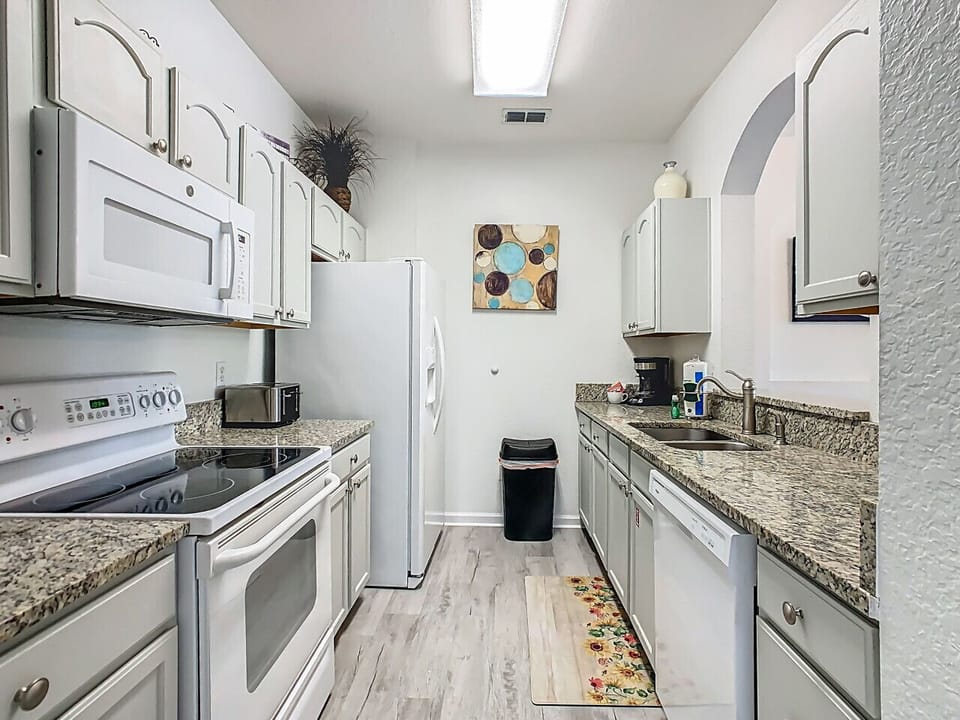 Spacious kitchen with appliances and granite countertops.