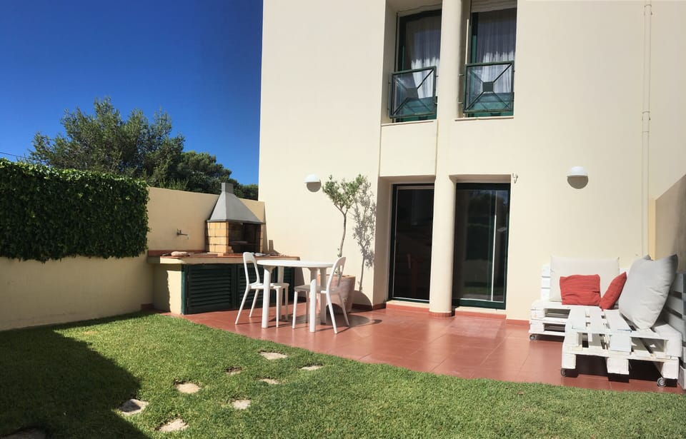 Zona exterior privada com pequeno jardim, área lounge e barbecue