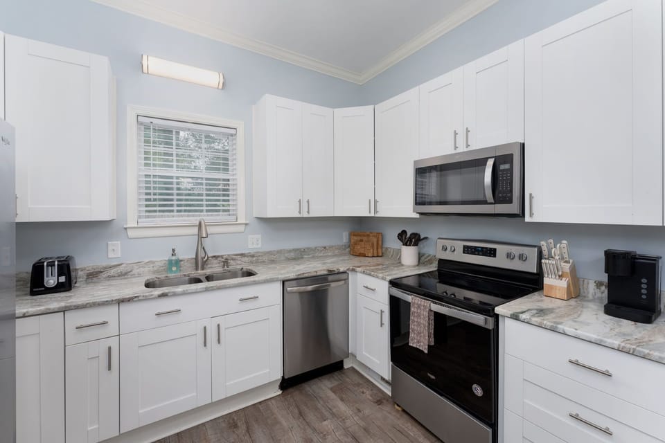 Modern kitchen with white cabinets, a sleek faucet, and a large sink.