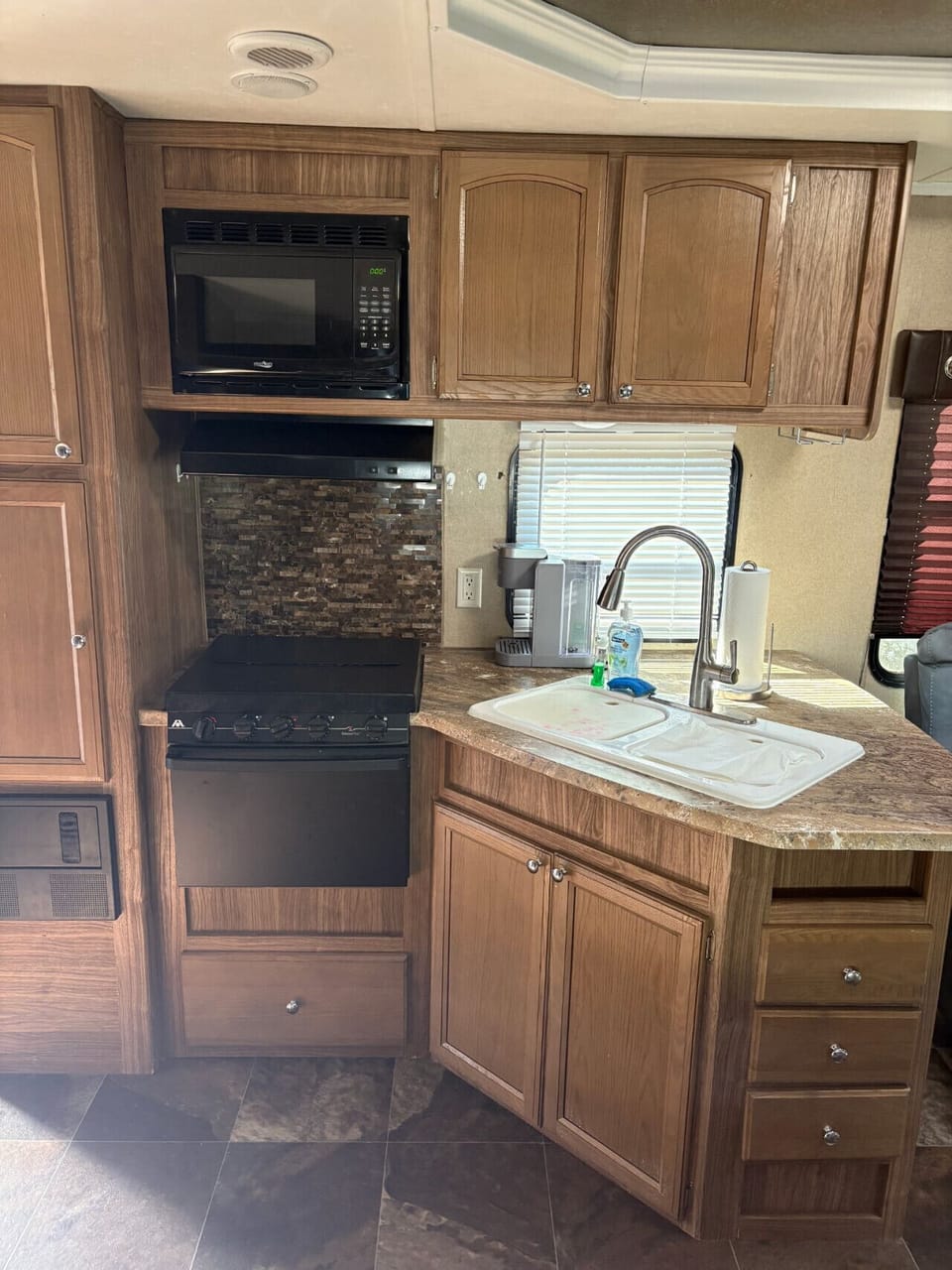 Small but mighty! This camper kitchen has everything you need—sink, stove, oven, and microwave—whether you`re whipping up lakeside pancakes or late-night snacks.