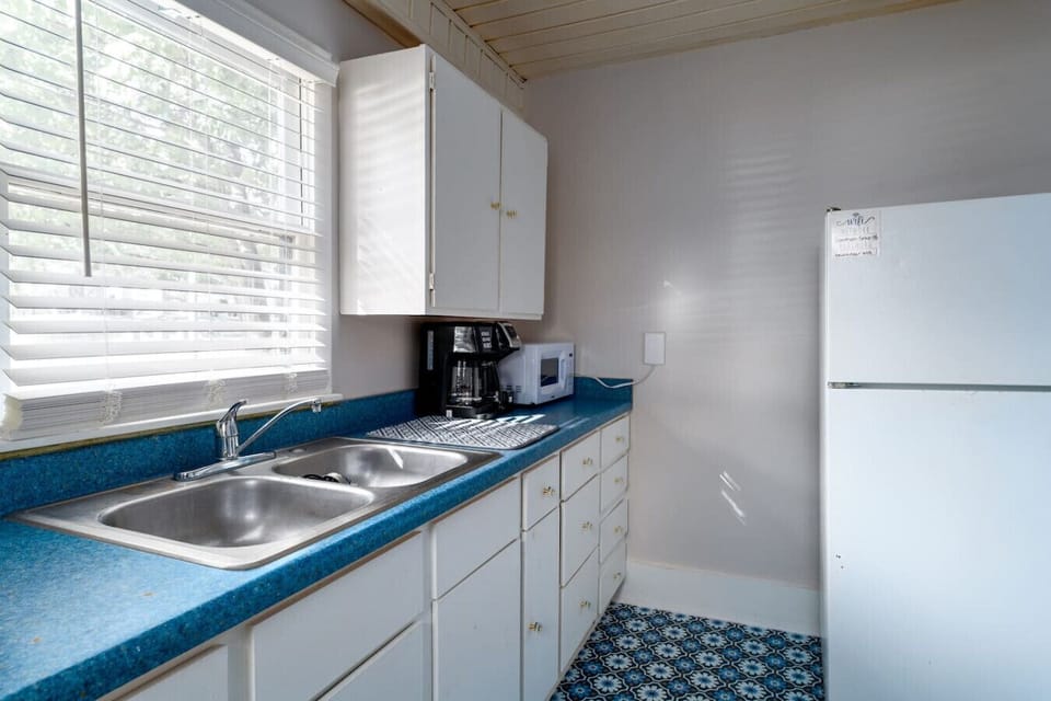 Clean kitchen with blue countertops, double sink, and white appliances.