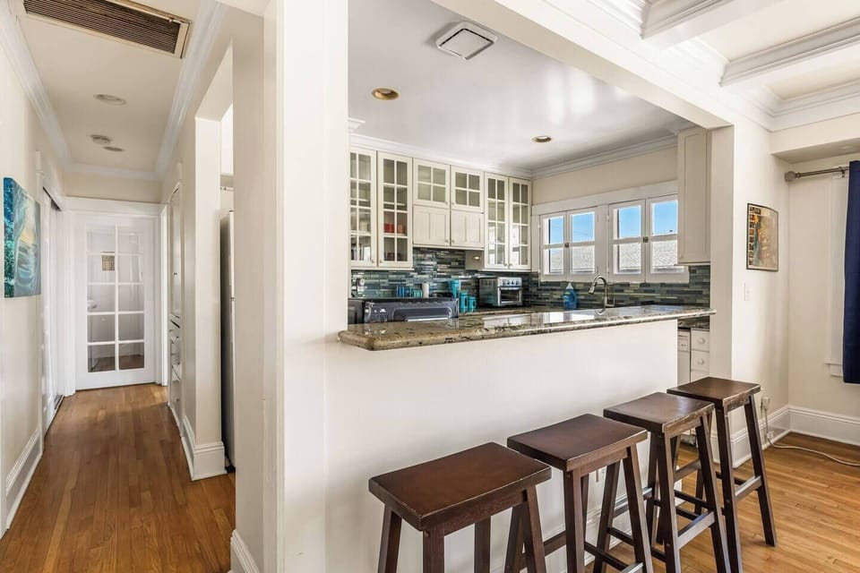 Modern kitchen with all the essentials—coffee machine, blender, microwave, and dishwasher. Enjoy meals or morning coffee at the cozy dining area with seating for four. A bright, functional space perfect for cooking, dining, and relaxing