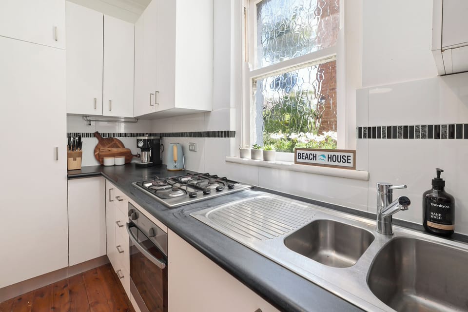 Kitchen with gas cooktop, oven, microwave, coffee machine, fridge