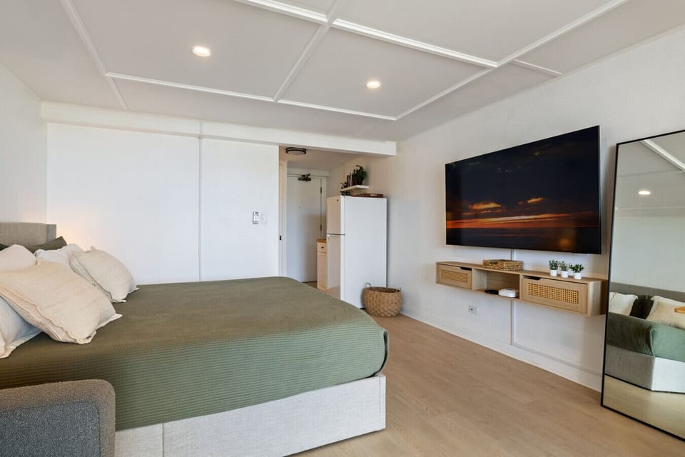 Clean and restful bed area with a warm, welcoming vibe and natural light.