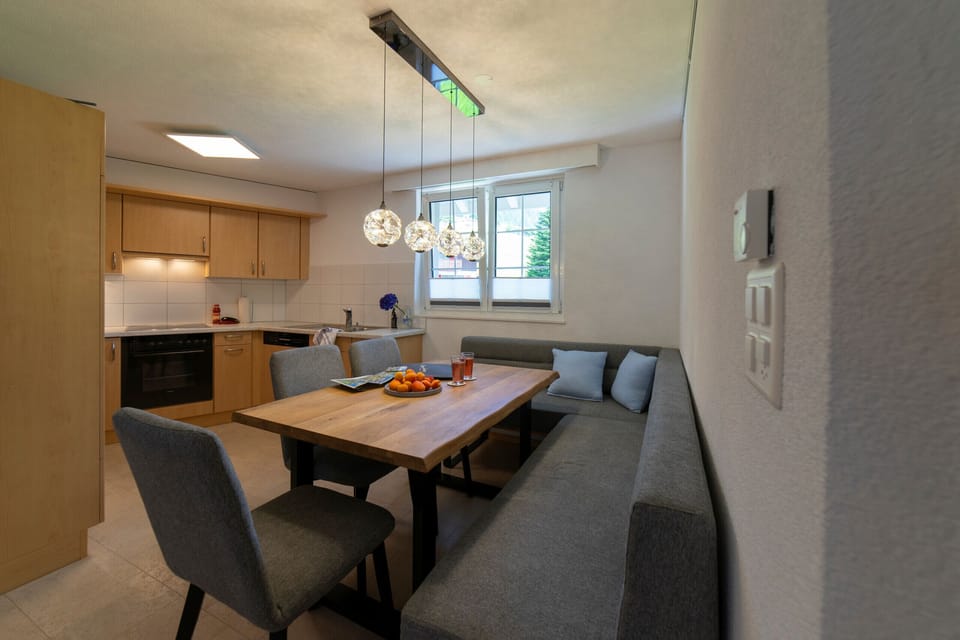 Dining area with a corner bench, wooden table and adjoining kitchen