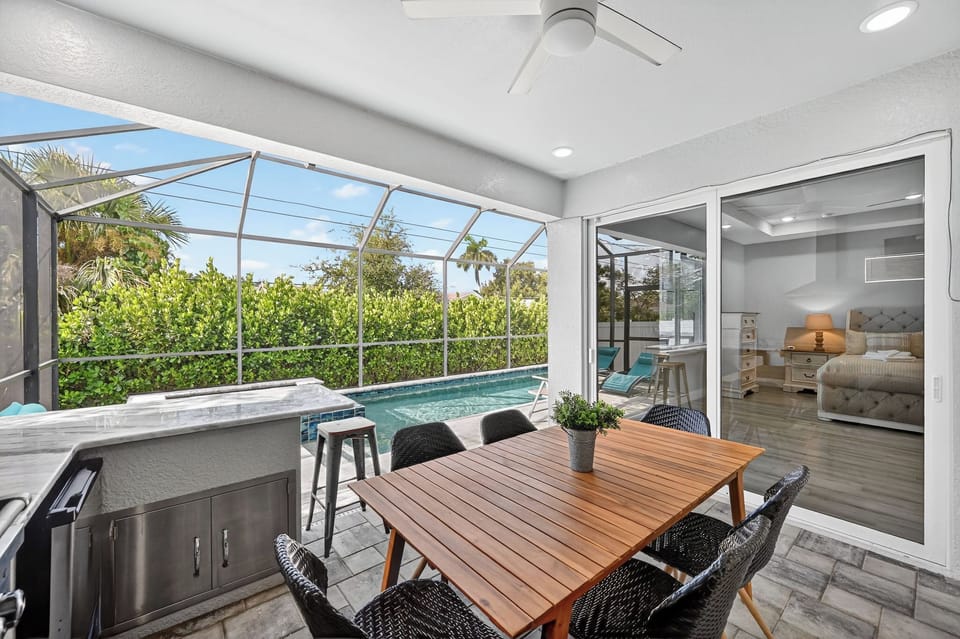 Screened Patio: Dine al fresco beside the sparkling pool, surrounded by lush greenery and sunshine!