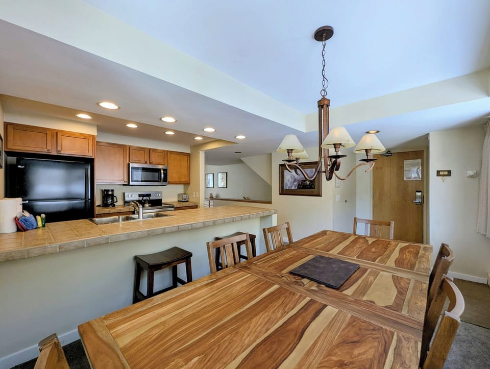 Your open-concept kitchen and dining area features a breakfast bar and spacious table, perfect for gathering with family and friends over home-cooked meals.