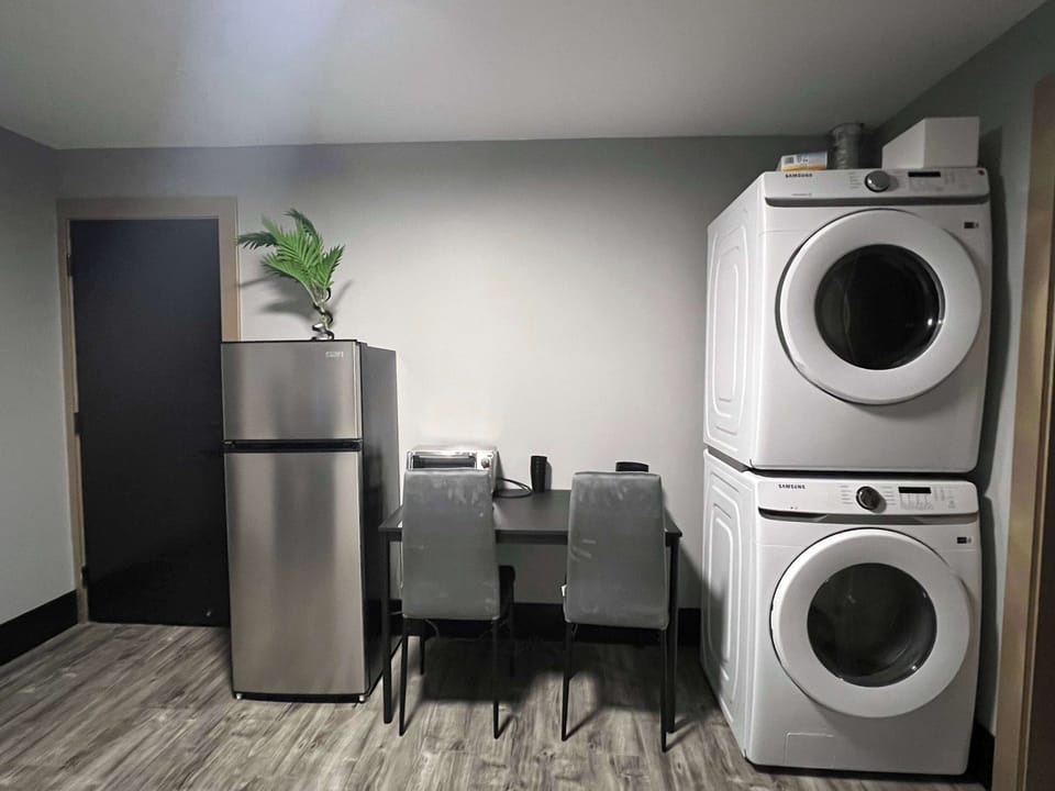 A unique dual-purpose space with full-size washer & dryer, dining area, and fridge, combining convenience and smart use of space in one spot.