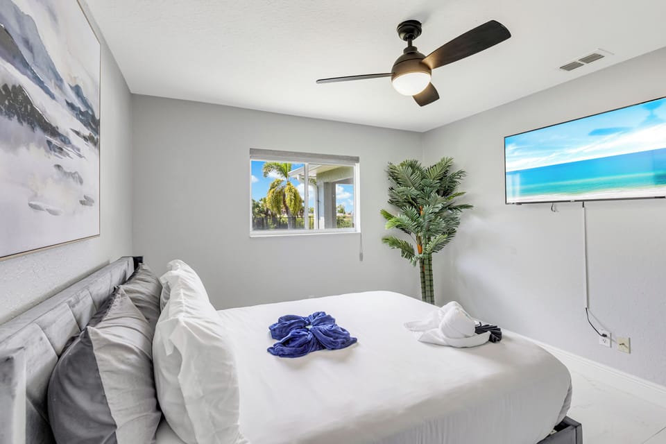 Guest bedroom with queen bed and wall-mounted smart TV