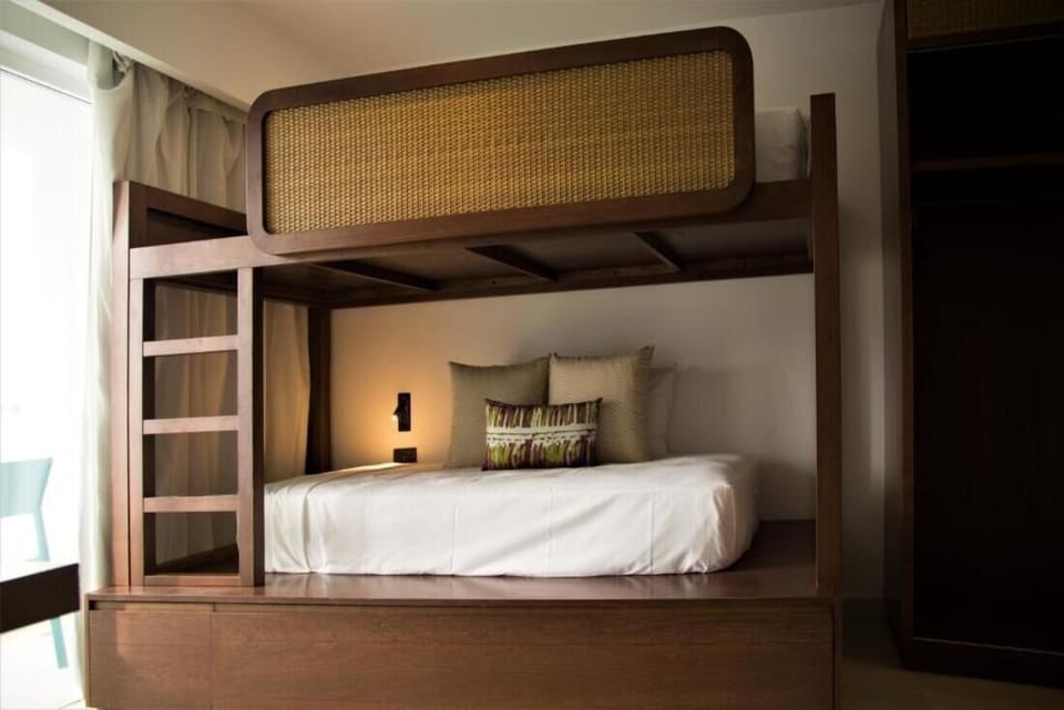 Unwind in cozy bunks with crisp linens and warm light.