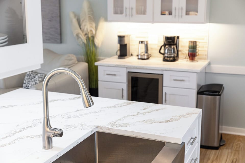 Bright modern kitchenette with coffee bar and stylish marble-look counters