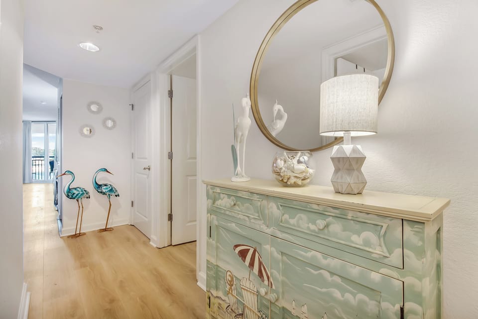 You'll love the elegant entryway with its hand-painted dresser, golden mirror, and charming flamingo sculptures creating a warm welcome home.