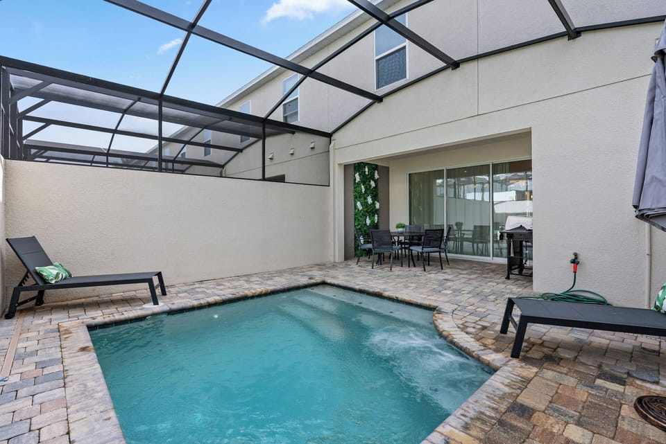 Step into your private oasis, where a crystal-clear pool invites you to unwind. Surrounded by a stylish paver patio and shaded loungers, this serene outdoor space is perfect for relaxation or al fresco dining under the sunlit sky.