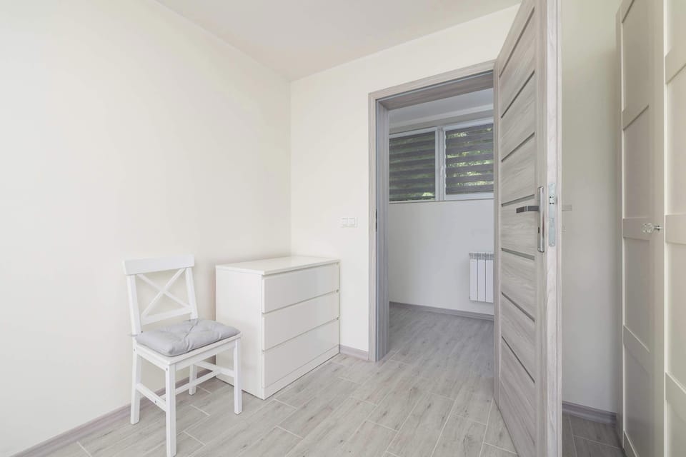 A chest of drawers and a closet in the room.