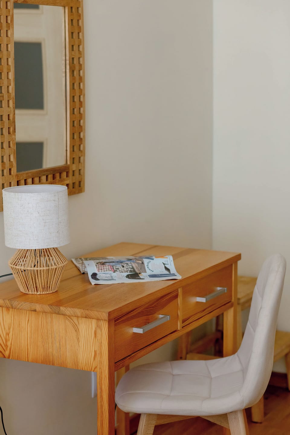 A closer look at the dressing table reveals a mirror, chair, and small decorative items. The setup feels tidy and functional.