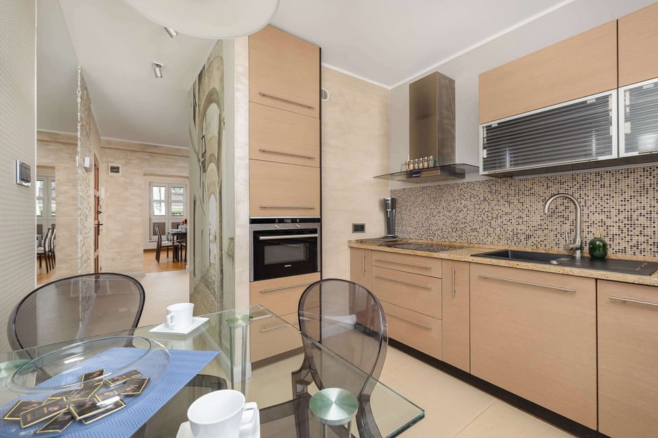 A different perspective of the kitchen, showcasing additional counter space and contemporary design. The warm tones of the cabinetry complement the sleek appliances.