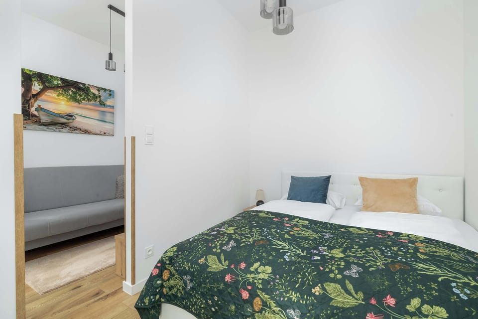 The bedroom viewed from a different angle with white and green bedding.