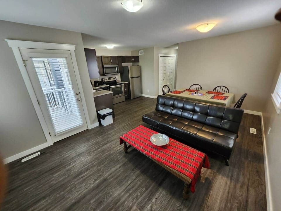 Open concept living room, hider bed with door leading to balcony