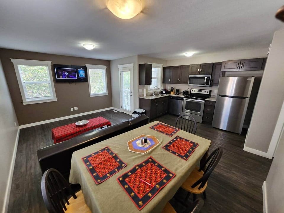 Open Concept space, including TV room, dining and kitchen space with living room hider bed, with door leading to the balcony.