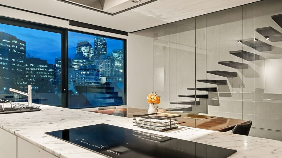 The space features a large kitchen island with a built-in induction cooktop.