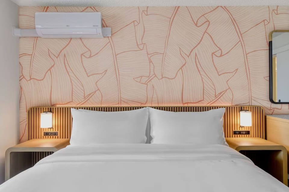 Recharge in a cloud-soft bed with cozy bedside glow.