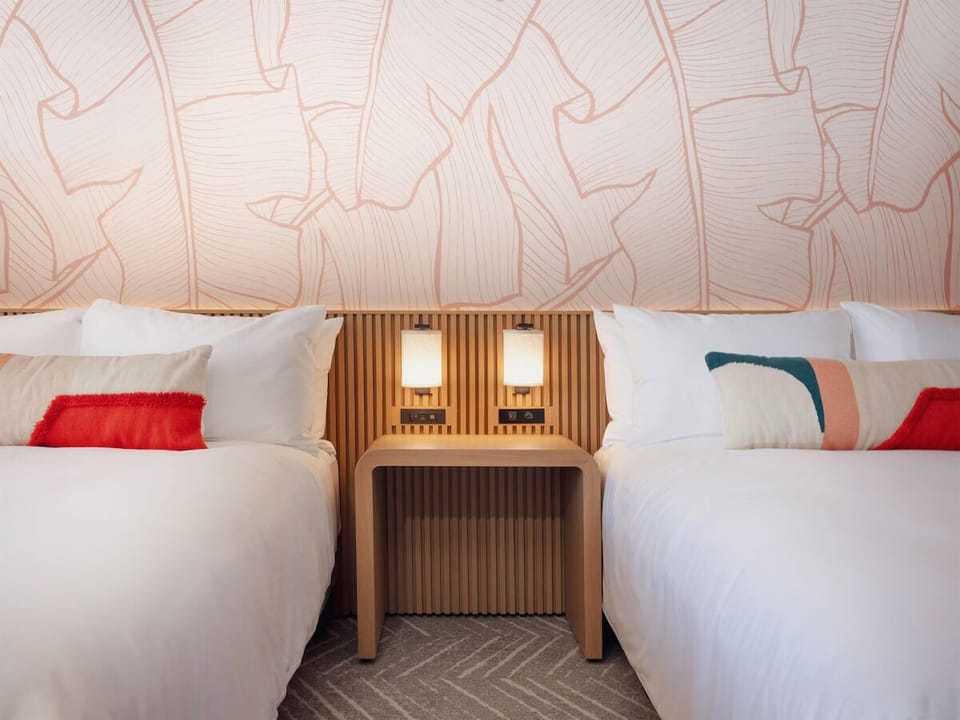 Unwind into crisp linens beneath warm, calming bedside glow.