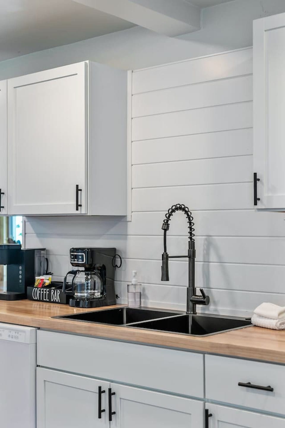 Coffee bar includes starter supplies of ground coffee, K-cups, tea, creamer, and sweeteners.